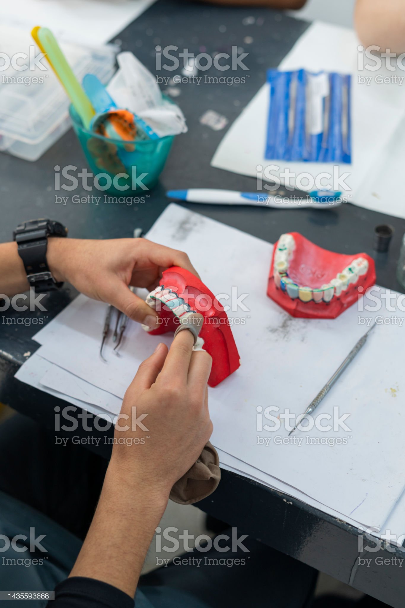 Hands of a Latina dentistry student from Bogota Colombia between 20 and 24 years old, working in class with her work implements